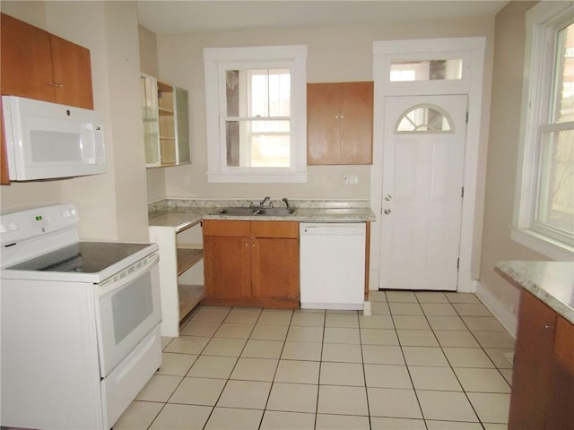 kitchen with light tile patterned floors, white appliances, and sink