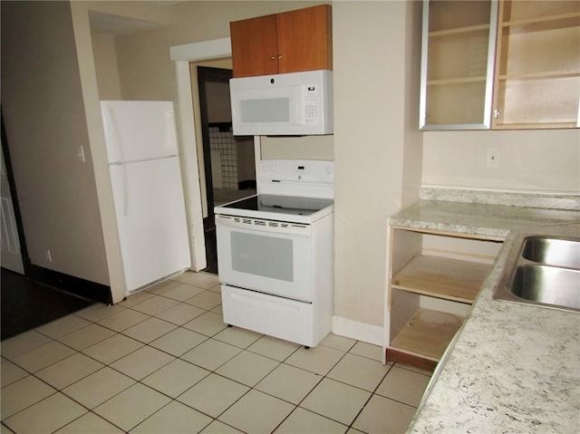 kitchen with sink, light tile patterned floors, and white appliances