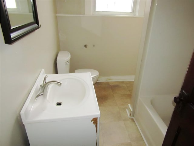 bathroom with vanity, toilet, and a washtub