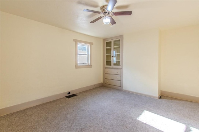 spare room with ceiling fan and carpet