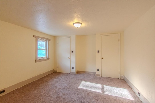 carpeted empty room with a textured ceiling