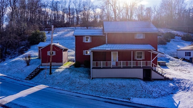 front of property with a porch and a storage shed