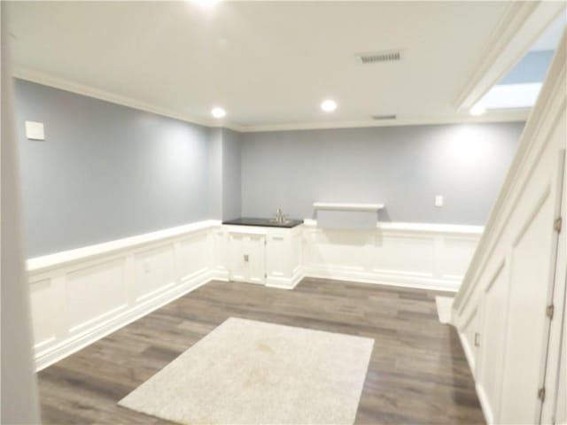 interior space with ornamental molding and hardwood / wood-style flooring