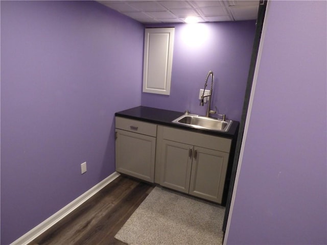 bathroom with wood-type flooring, vanity, and a drop ceiling