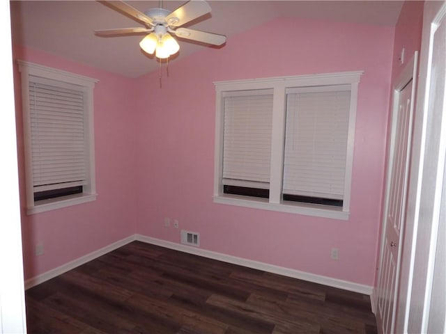 empty room with vaulted ceiling, ceiling fan, and dark wood-type flooring