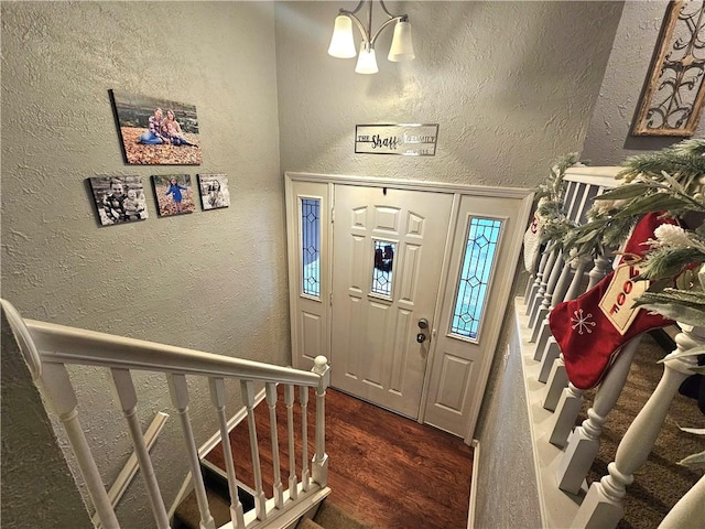 foyer with a notable chandelier and dark wood-type flooring