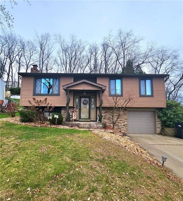 raised ranch with a garage and a front yard