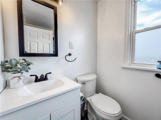 bathroom with plenty of natural light, vanity, and toilet