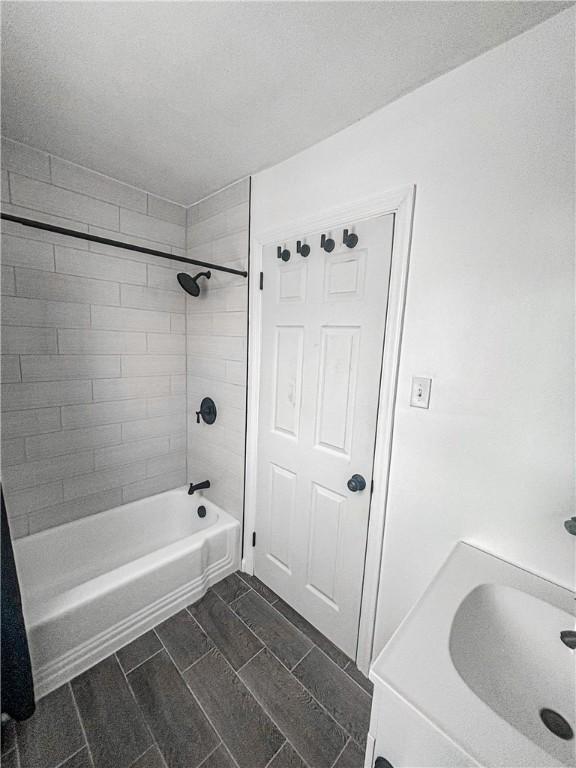 bathroom featuring tiled shower / bath combo and washer / clothes dryer