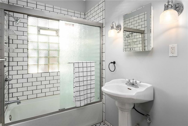 bathroom with plenty of natural light and bath / shower combo with glass door