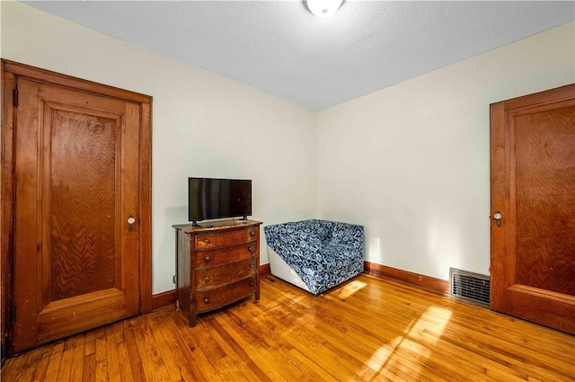 bedroom with hardwood / wood-style floors and a textured ceiling