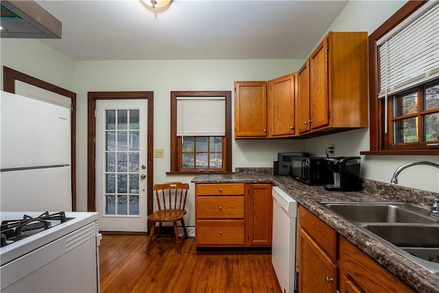 kitchen with dark hardwood / wood-style flooring, white appliances, and sink