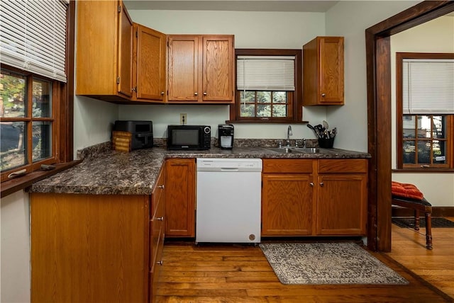 kitchen featuring light wood-type flooring, white dishwasher, and plenty of natural light