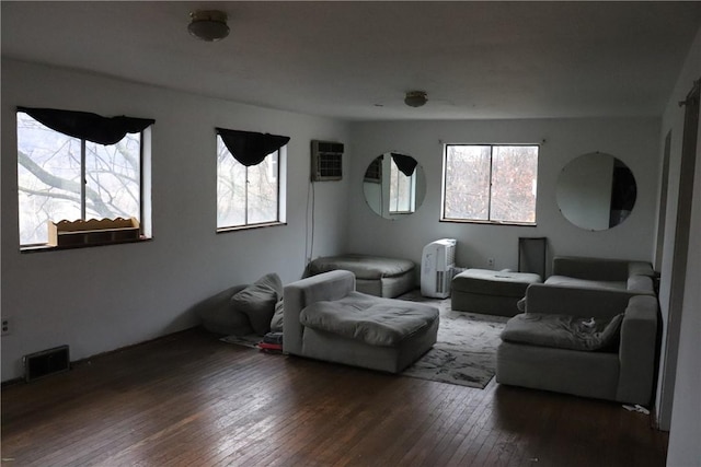 home theater with a wall mounted air conditioner and dark hardwood / wood-style floors