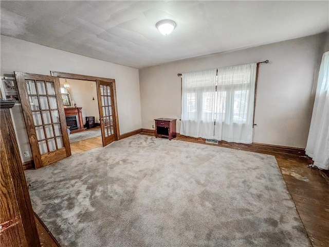 spare room featuring carpet floors and french doors