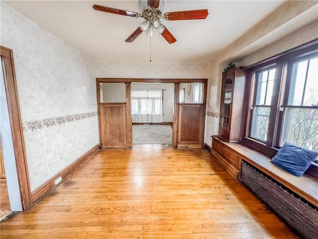 unfurnished living room with ceiling fan, light hardwood / wood-style flooring, and a healthy amount of sunlight