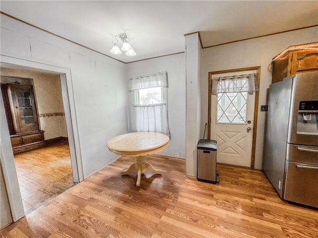 dining space with light hardwood / wood-style flooring and a notable chandelier