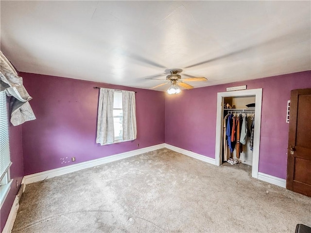 unfurnished bedroom with a walk in closet, carpet floors, a closet, and ceiling fan