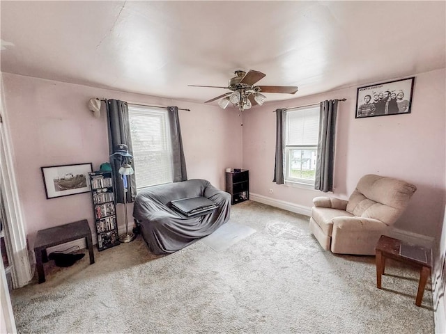 living area featuring carpet flooring and ceiling fan