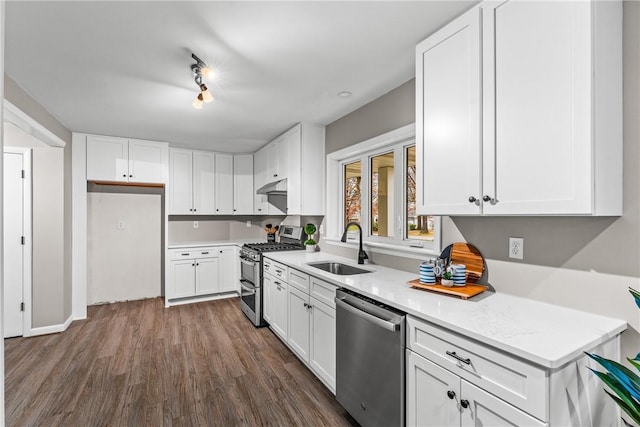 kitchen featuring light stone countertops, sink, dark wood-type flooring, stainless steel appliances, and white cabinets