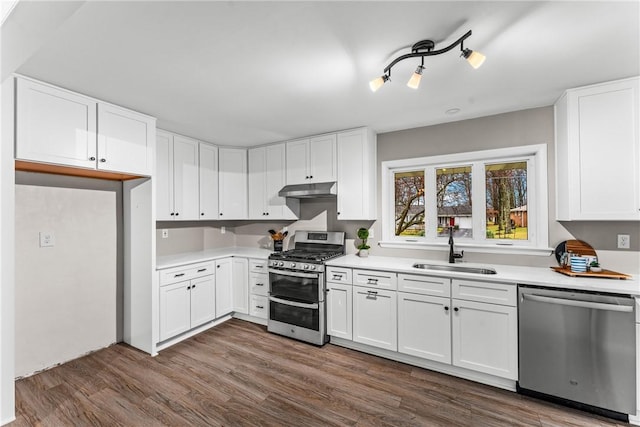 kitchen featuring white cabinetry, sink, appliances with stainless steel finishes, and dark wood-type flooring