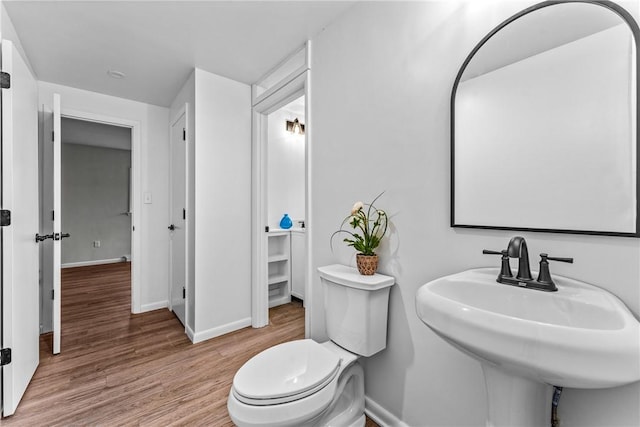 bathroom featuring sink, wood-type flooring, and toilet