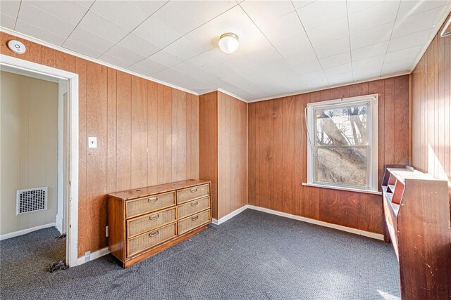 carpeted empty room with wooden walls