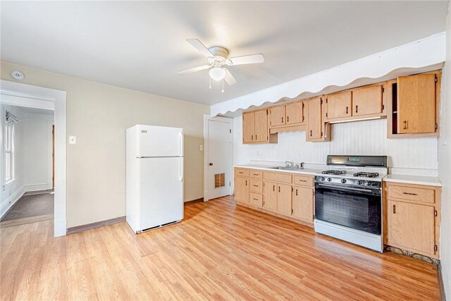 kitchen with ceiling fan, white appliances, sink, and light hardwood / wood-style flooring