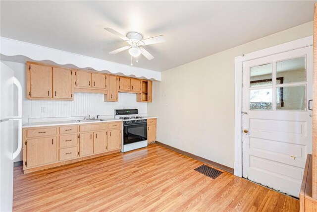 kitchen featuring white appliances, ceiling fan, sink, light brown cabinets, and light hardwood / wood-style floors