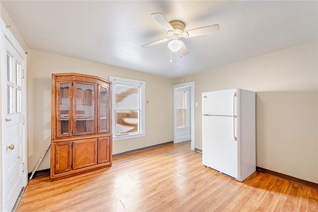 kitchen featuring ceiling fan, white fridge, and light wood-type flooring