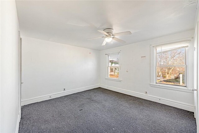 unfurnished room with ceiling fan and dark colored carpet