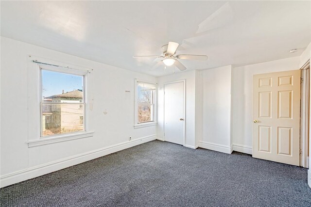 unfurnished bedroom with dark colored carpet and ceiling fan