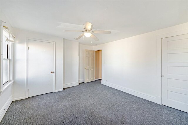 unfurnished bedroom with dark colored carpet and ceiling fan