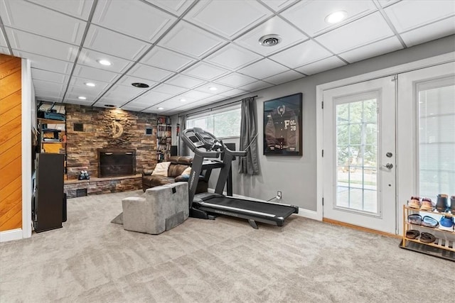 exercise area with a wealth of natural light, a fireplace, and light carpet