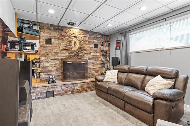 carpeted living room with a stone fireplace