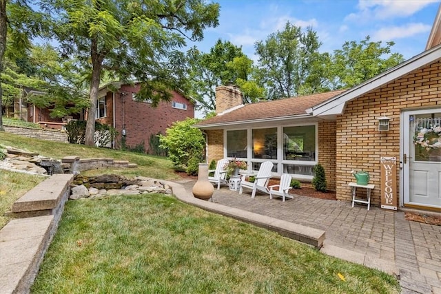 back of property with a yard and a patio