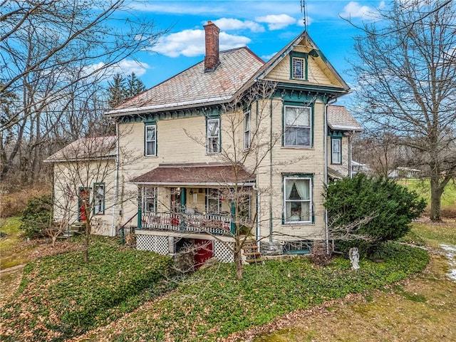 back of property featuring a lawn and a porch