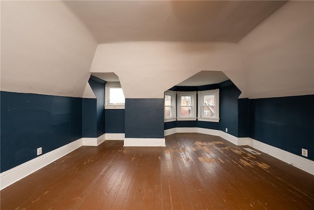 bonus room with dark hardwood / wood-style flooring and vaulted ceiling