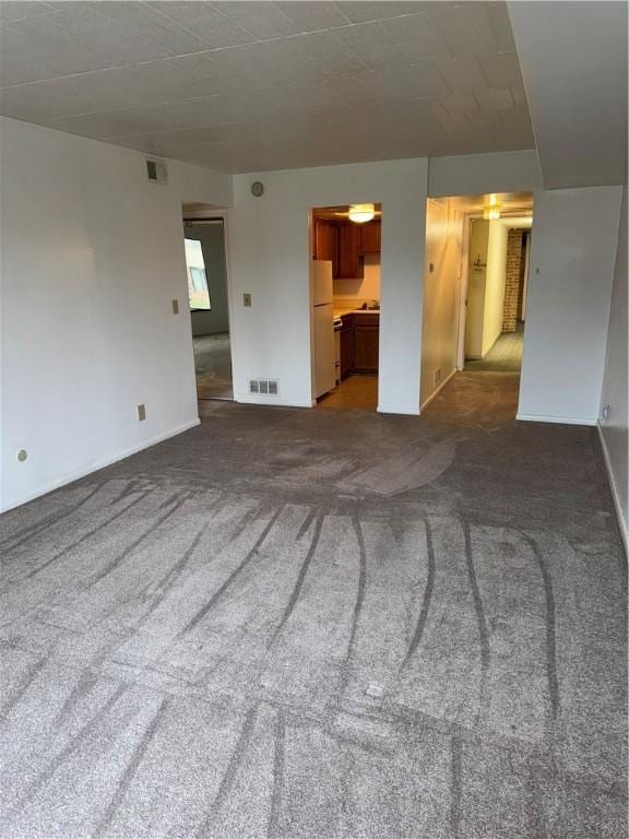 unfurnished living room with dark carpet