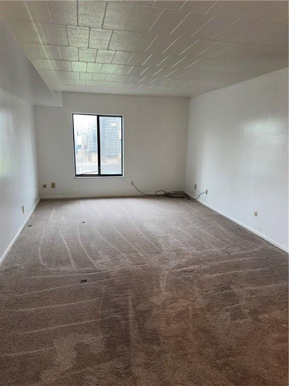 spare room with dark colored carpet