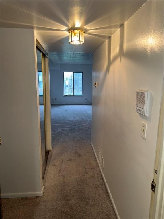 hall with dark colored carpet