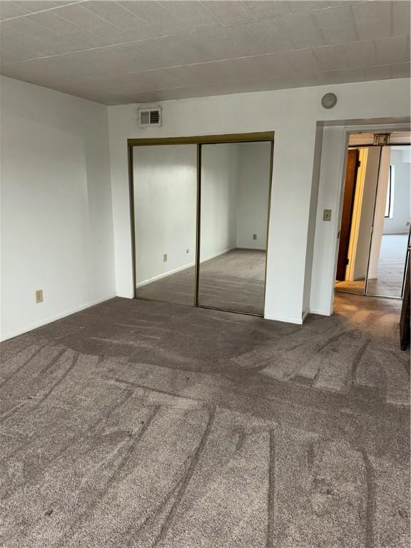 unfurnished bedroom with a closet and carpet floors