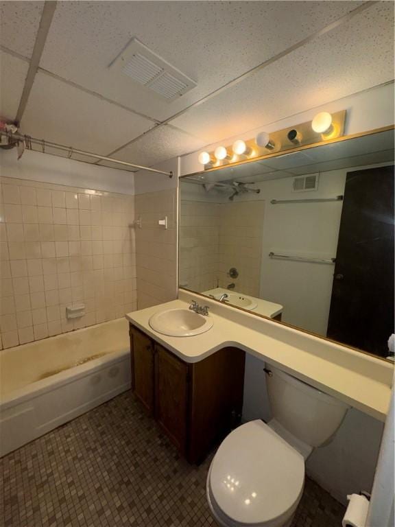 full bathroom featuring vanity, tiled shower / bath combo, and toilet