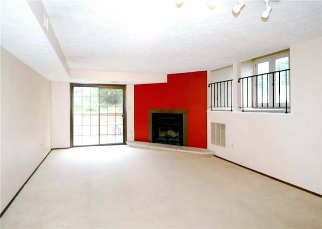 unfurnished living room featuring carpet and a textured ceiling