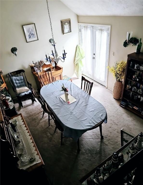 dining area featuring lofted ceiling and carpet floors