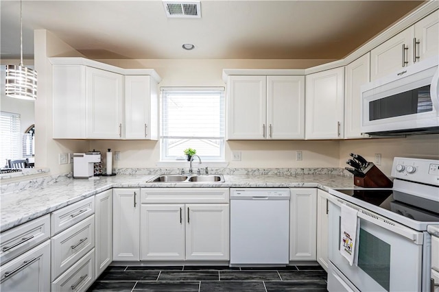 kitchen with white cabinets, plenty of natural light, white appliances, and sink