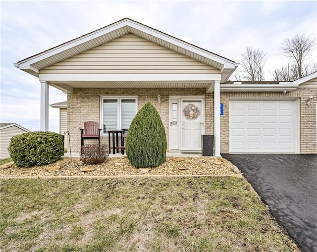 view of front of property featuring covered porch, a garage, and a front lawn