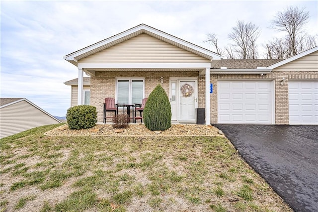 ranch-style home with a front yard, a porch, and a garage