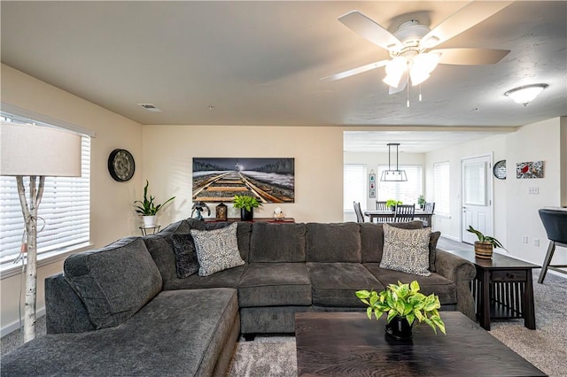 carpeted living room with ceiling fan