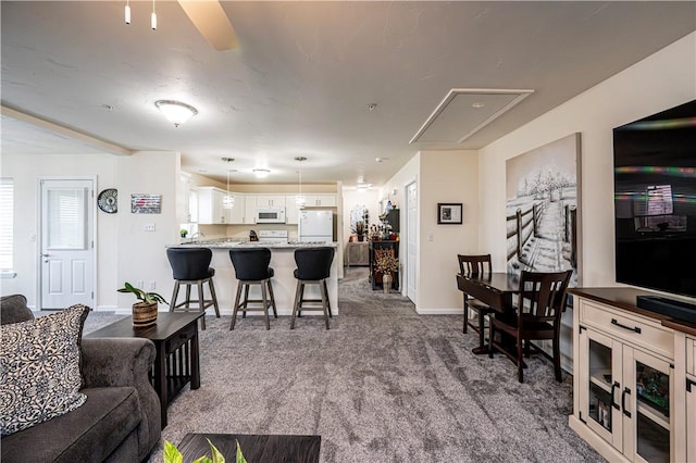 living room featuring ceiling fan and dark colored carpet